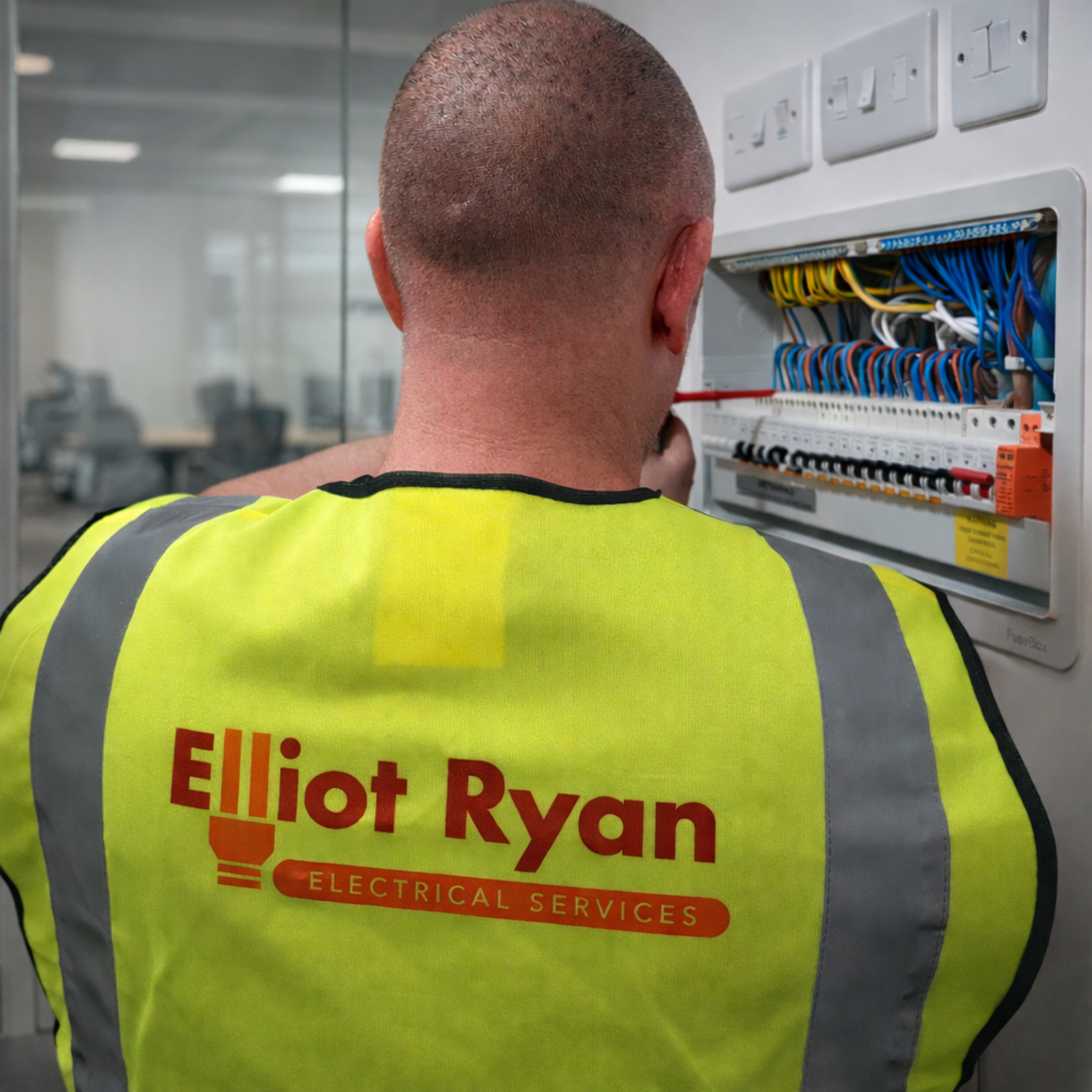 Electrical technician servicing panel in office